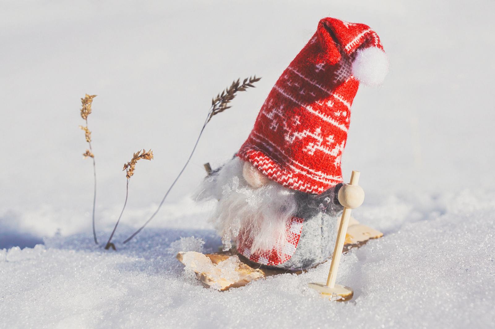 Cute gnome figurine skiing in snowy landscape, adding charm to winter decorations.