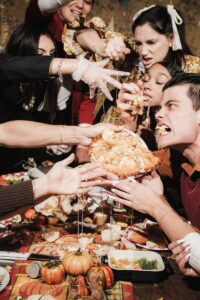 Lively scene of friends engaged in a Thanksgiving food fight around a festive table.