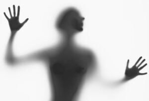 A mysterious silhouette of a woman behind frosted glass, evoking intrigue.