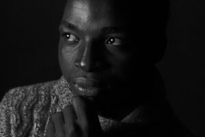 Black and white portrait of a man in deep thought, capturing contemplative mood.